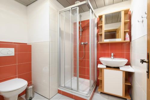 ein Bad mit einer Dusche, einem WC und einem Waschbecken in der Unterkunft Kurcamping Erlengrund in Bad Gastein