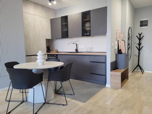 a kitchen with a table and chairs and a sink at BS Apartment in Skopje