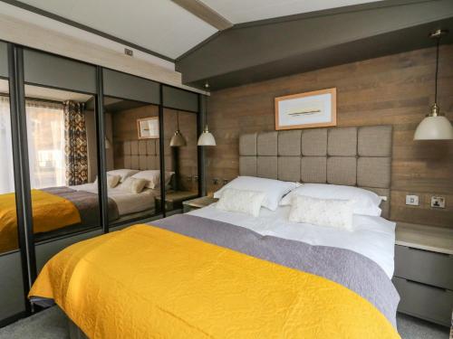 een slaapkamer met een groot bed en een gele deken bij Hollybirch in Crieff