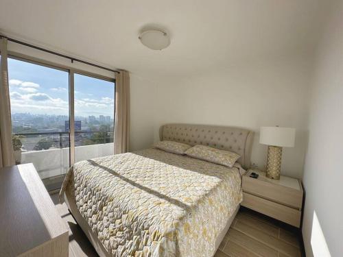 a bedroom with a bed and a large window at Modern 3 Bedroom Rental Unit With Free Parking in Guatemala