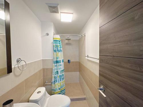 y baño con aseo y cortina de ducha. en Modern 3 Bedroom Rental Unit With Free Parking, en Guatemala