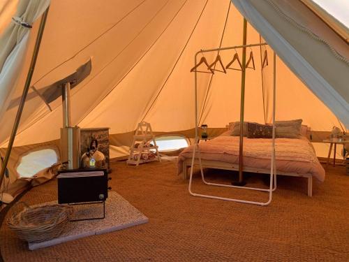 a bedroom with a tent with a bed in it at Au Pré Fleuri Eco Glamping in Le Lindois