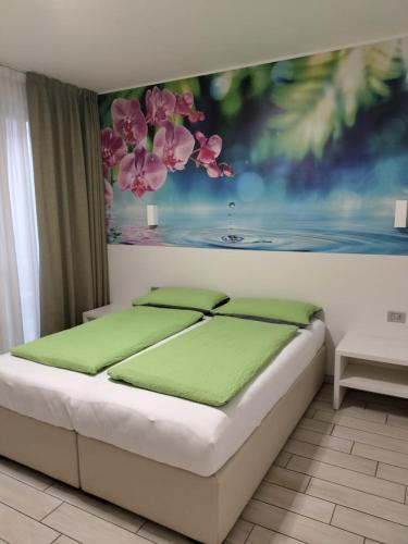 a bedroom with a bed with a painting on the wall at Agriturismo Vin e Amor in Dro