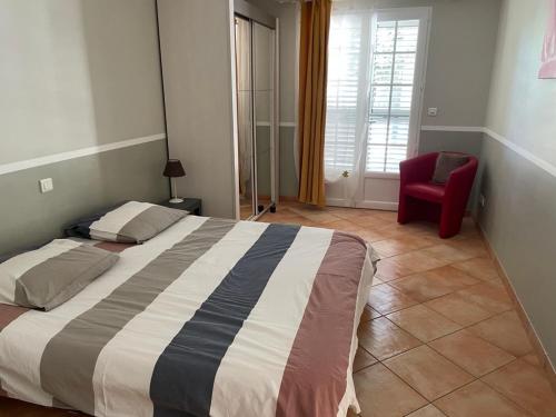ein Schlafzimmer mit einem großen Bett und einem roten Stuhl in der Unterkunft Villa Lavezzi in Bonifacio