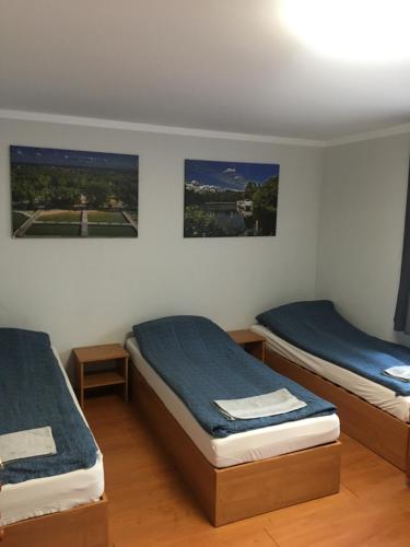 アウグストゥフにあるApartament Augustówの壁に絵画が飾られた客室内のベッド2台