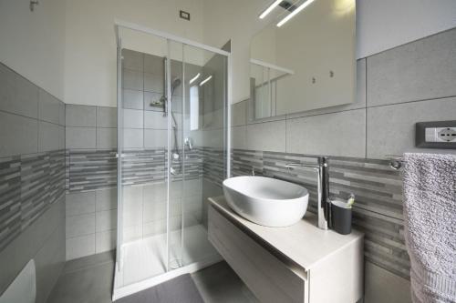 ein weißes Badezimmer mit einem Waschbecken und einem Spiegel in der Unterkunft B&B Il Sogno di Mario in Carbonia
