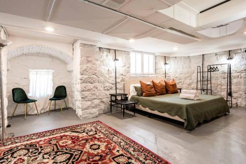 1 dormitorio con cama y pared de piedra en Spacious Castle House w/ Yard + Great Location!, en Louisville