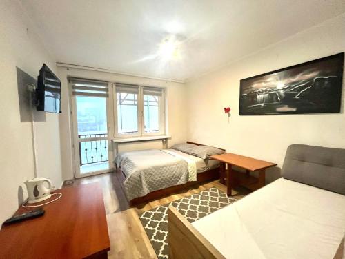 シュクラルスカ・ポレンバにあるWilla Victoriaのベッド2台とテーブルが備わる小さな客室です。
