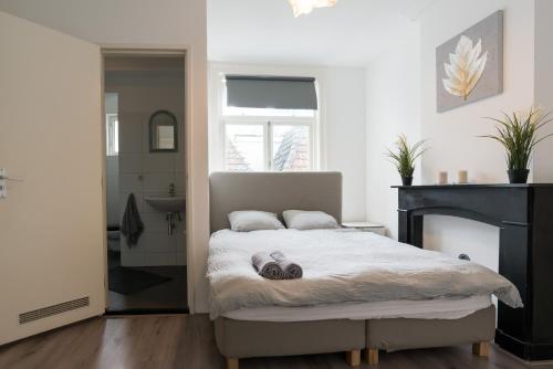 een slaapkamer met een bed en een open haard bij Beautiful House next to Dam Square! in Amsterdam