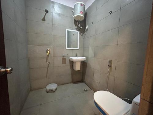 La petite salle de bains est pourvue de toilettes et d'un lavabo. dans l'établissement The Chaitanya United Stay, à New Delhi