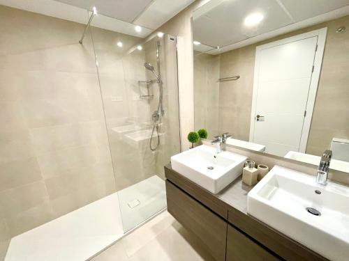 ein Bad mit einem Waschbecken, einer Dusche und einem Spiegel in der Unterkunft Luxury 3 Bedroom Apartment 300m from the Beach in Fuengirola
