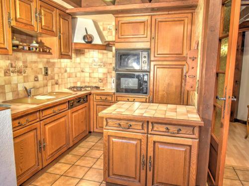La cuisine est équipée de placards en bois, d'un évier et d'un four micro-ondes. dans l'établissement Appartement 70m² pour 8 au centre de Morzine, proche pistes et commerces, avec garage privé - FR-1-524-2, à Morzine