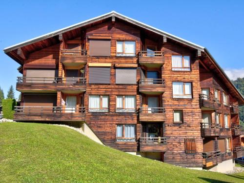 un grand bâtiment en bois au sommet d'une colline dans l'établissement Charmant studio près du centre de Morzine avec loggia et parking, idéal pour 4 personnes - FR-1-524-5, à Morzine