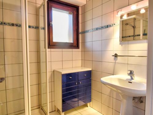 La salle de bains est pourvue de carrelage blanc, d'un lavabo et d'une fenêtre. dans l'établissement Bel Appartement 40m², Proche Centre Morzine, 6 Pers., Balcons, Animaux Admis - FR-1-524-23, à Morzine