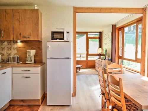 une cuisine avec un réfrigérateur blanc et une table dans l'établissement Appartement rénové, skis aux pieds, proche centre avec parking et balcon - FR-1-524-30, à Morzine