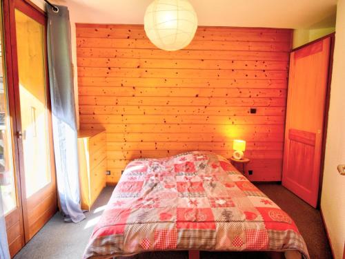 une chambre avec un lit dans un mur en bois dans l'établissement Appartement cosy 2 pièces, proche centre Morzine, balcon, parking, animaux admis - FR-1-524-24, à Morzine