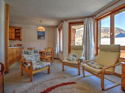 un salon avec des chaises, une table et des fenêtres dans l'établissement Appartement 3 pièces rénové, pieds des pistes et proche centre, Morzine - FR-1-524-35, à Morzine