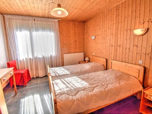 une chambre avec deux lits et une table et une fenêtre dans l'établissement Appartement rénové avec 3 pièces, parking, proche centre et commodités à Morzine - FR-1-524-8, à Morzine