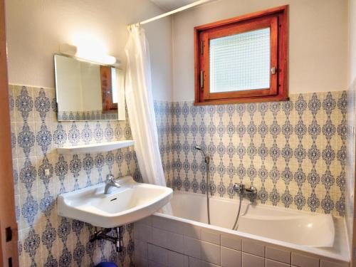 une salle de bain avec un lavabo, une baignoire et un miroir dans l'établissement Charmant 2 pièces au centre de Morzine avec parking et WiFi - FR-1-524-56, à Morzine
