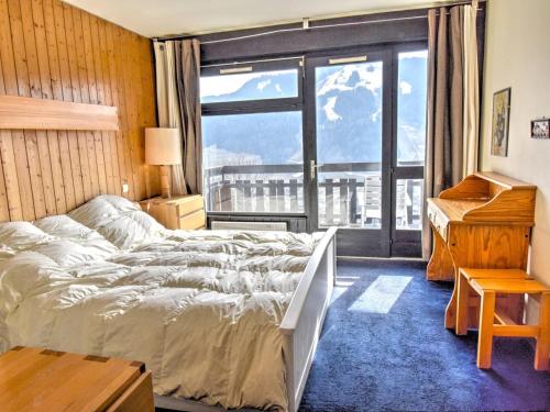 une chambre avec un lit et une grande fenêtre dans l'établissement Charmant 2 pièces avec piscine et parking, proche des pistes à Morzine - FR-1-524-75, à Morzine
