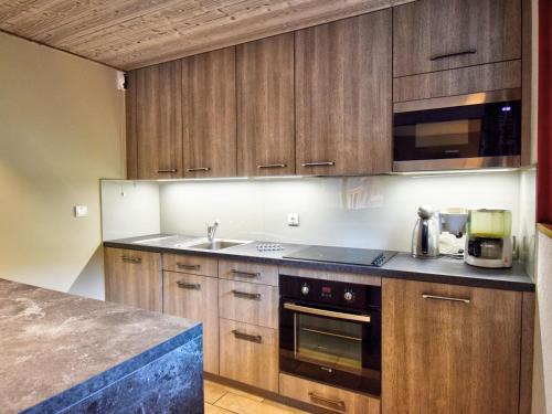 une cuisine avec des armoires en bois et un comptoir dans l'établissement Appartement duplex spacieux et équipé, proche centre de Morzine, navettes gratuites, garage privé - FR-1-524-9, à Morzine