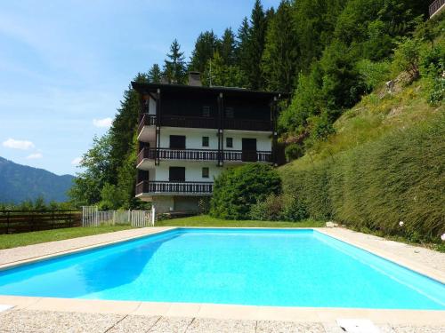 une grande piscine bleue devant un immeuble dans l'établissement Charmant 2 pièces avec piscine et parking, proche des pistes à Morzine - FR-1-524-75, à Morzine