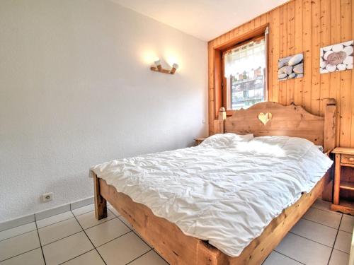 une chambre avec un grand lit avec des draps blancs dans l'établissement Appartement 2 pièces à Morzine, centre-ville, proche pistes, balcon sud, parking couvert, 6 couchages - FR-1-524-41, à Morzine