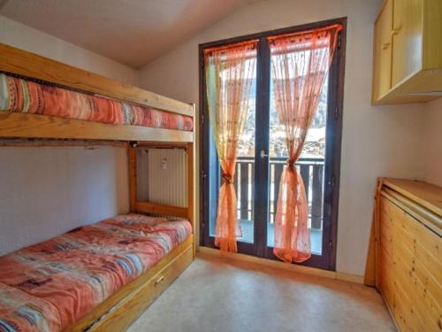 une chambre avec un lit superposé et une grande fenêtre dans l'établissement Appartement 2 pièces près du centre de Morzine avec balcon et parking, animaux admis - FR-1-524-44, à Morzine