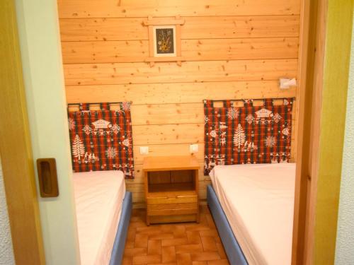 une petite chambre avec deux lits et une table dans l'établissement Studio agréable, centre de Morzine, garage, Wifi - FR-1-524-76, à Morzine