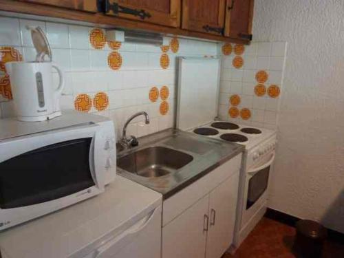 une petite cuisine avec un évier et une cuisinière dans l'établissement Studio à Morzine, 4 pers, proche centre, parking, wifi - FR-1-524-81, à Morzine