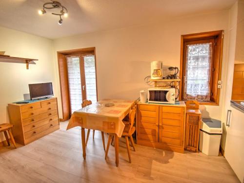 une cuisine avec une table en bois et un micro-ondes dans l'établissement Studio rénové près du centre de Morzine, idéal pour 4 personnes avec terrasse et parking - FR-1-524-83, à Morzine