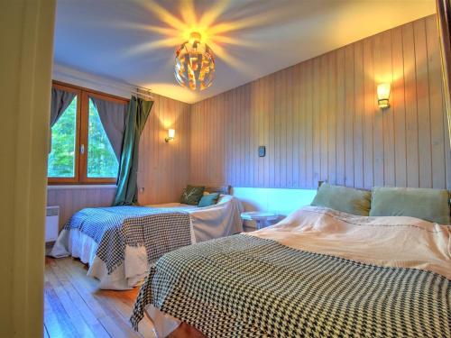 une chambre avec deux lits et un lustre dans l'établissement Charmant appt 2 chambres Morzine avec balcon, parking et Netflix - FR-1-524-97, à Morzine