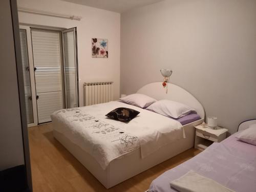 a dog laying on a bed in a bedroom at LEVANDA in Supetarska Draga