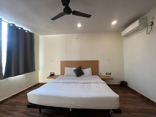 a bedroom with a large white bed with a ceiling fan at The Chaitanya United Stay in New Delhi