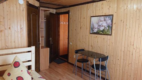 een slaapkamer met een bed, een tafel en stoelen bij Любе in Yablunytsia