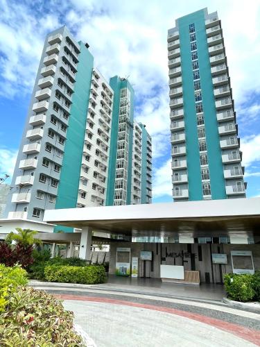 two tall buildings in front of a building at Cozy Condo bedroom in Bacolod City in Bacolod