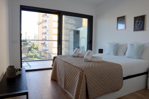 une chambre avec un lit avec une grande fenêtre dans l'établissement Monte Residence T1, à Portimão