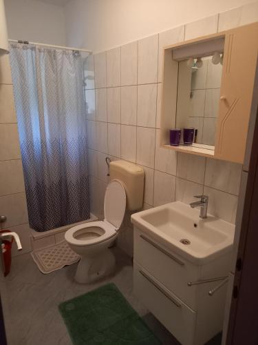 a bathroom with a toilet and a sink and a shower at LEVANDA in Supetarska Draga