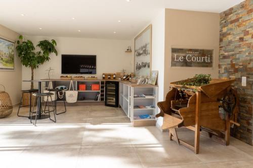 a living room with a table and a tv at Domaine Le Courti - Adult only in Le Barcarès