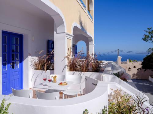 費拉的住宿－Casa di Magi，庭院配有白色的椅子和桌子,设有蓝色的门