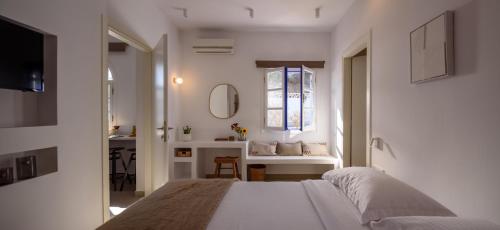 a white bedroom with a bed and a window at Casa di Magi in Fira