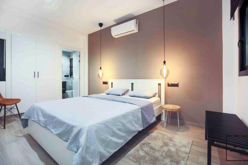 sypialnia z dużym białym łóżkiem i 2 krzesłami w obiekcie Perfectly Rentals ELIZA by United Renters w Alicante