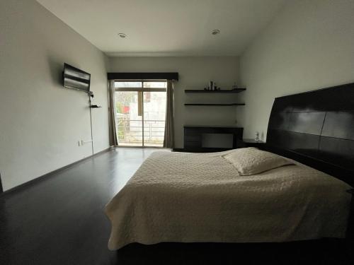a bedroom with a bed and a large window at Habitación Ojo de Agua in Orizaba