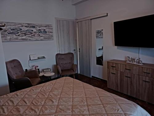 Cette chambre comprend un lit et une télévision à écran plat. dans l'établissement Mama Mia apartment, Tolo beachfront, à Tolón