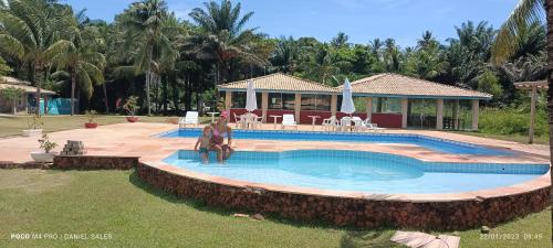 una piscina en un patio con una casa en Eco Pousada côco dendê, en Itacimirim