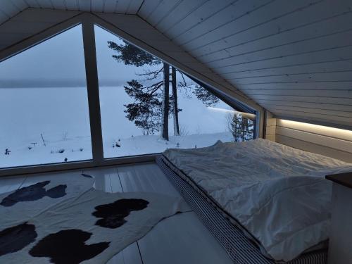 a bedroom with a bed in front of a window at VillaNorva in Saarenkylä