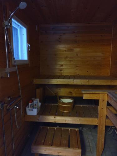 a sauna with a toilet in a wooden cabin at VillaNorva in Saarenkylä