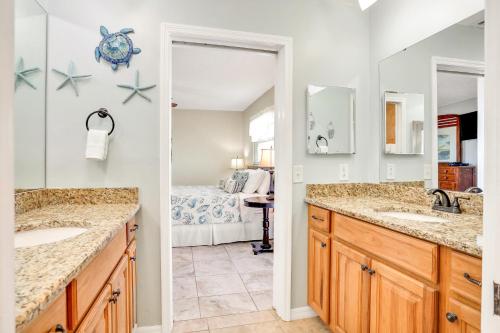 a bathroom with two sinks and a bedroom with a bed at Sea Breeze 608 in St Pete Beach