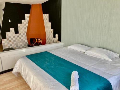 a bedroom with a large bed with a fireplace at Hostería El Troje Experience in Riobamba