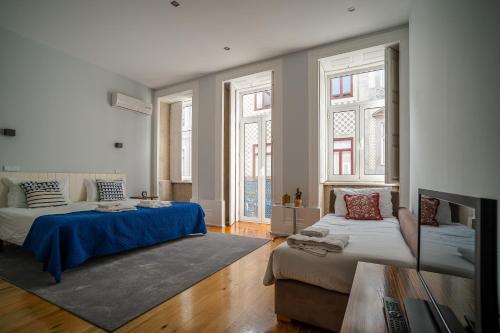 uma sala de estar com duas camas e um sofá em Oporto Trendy Apartments no Porto